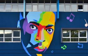 Portrait de John Coltrane en couleur sur fond bleu sur la façade de la médiathèque François Mitterrand